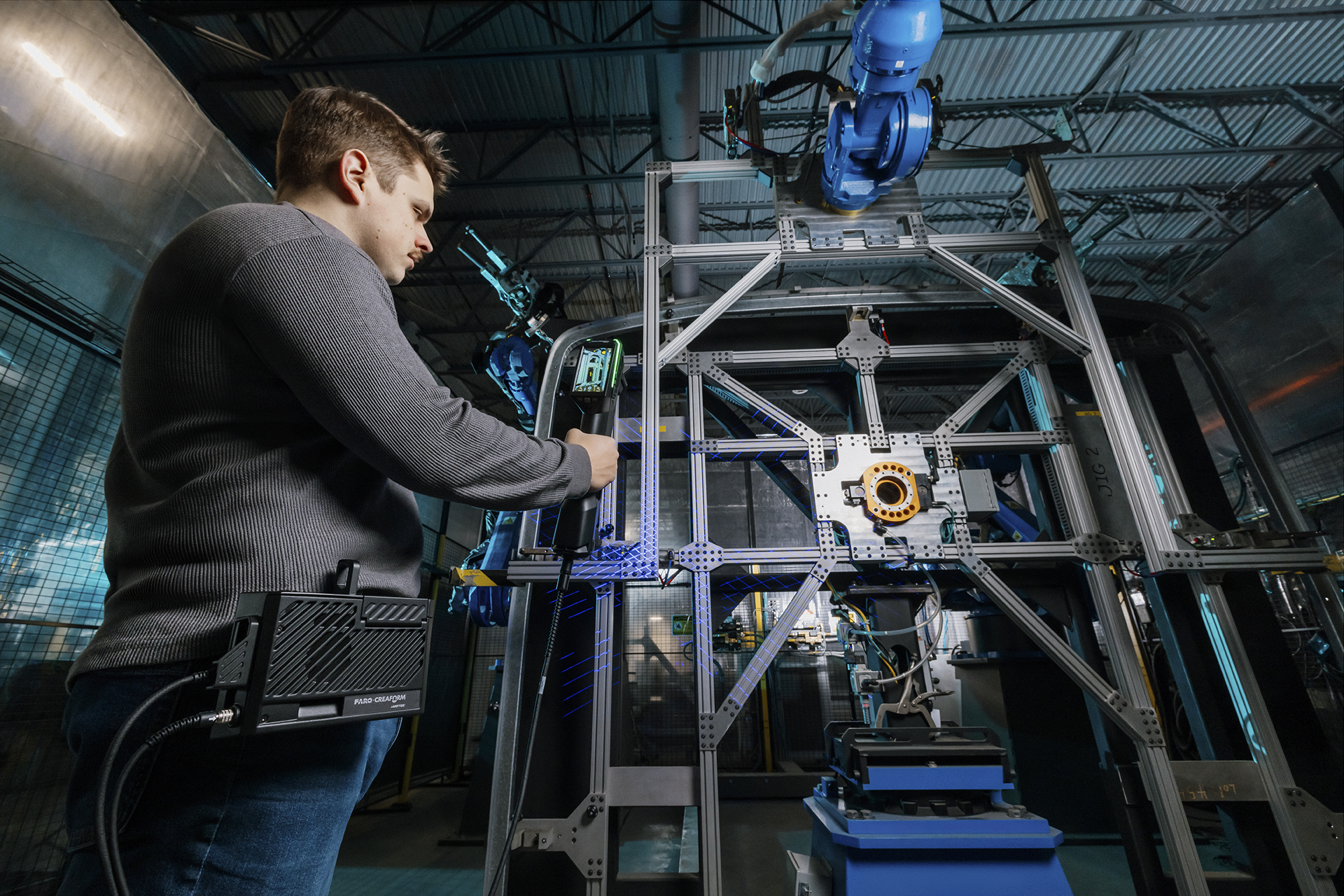 Um homem realizando uma inspeção de estruturas ao digitalizar um grande dispositivo de inspeção com o escâner HandySCAN 3D MAX Series e o Kit Mobilidade Sem Fio.