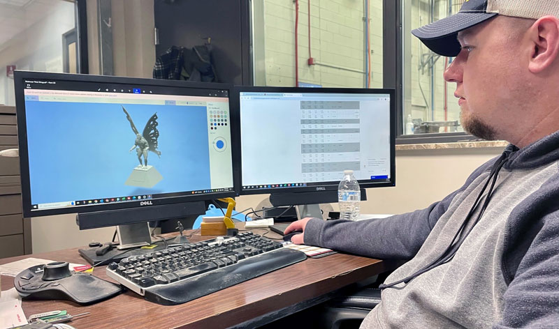 A MAMC expert assesses the 3D model of the Mothman statue on his computer screen.