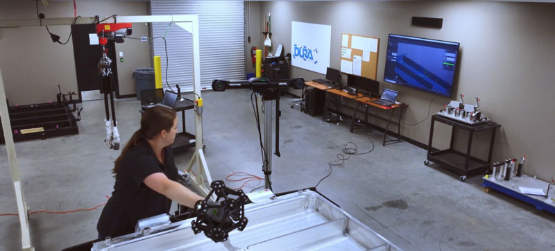 Technician looking at the live data capture while scanning an EV battery enclosure on the shop floor.