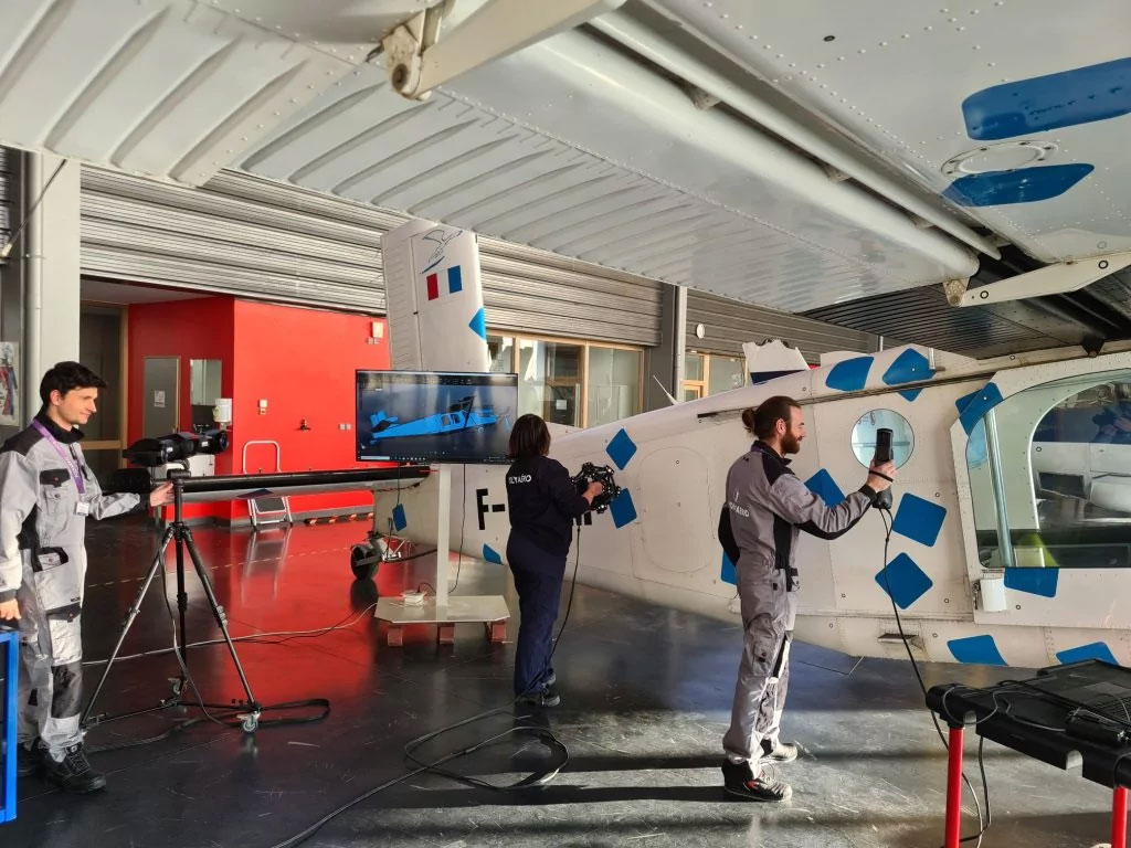 a man scans a Tesla car wheel with the HandySCAN 3D scanner