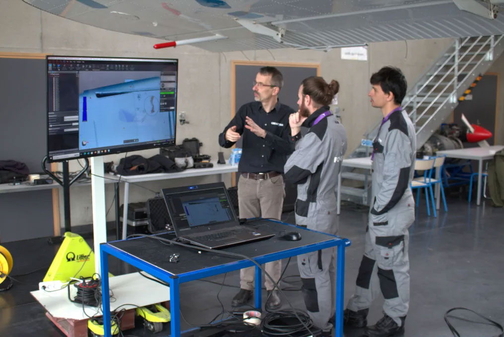 Trois personnes regardant un écran qui affiche une image en 3D