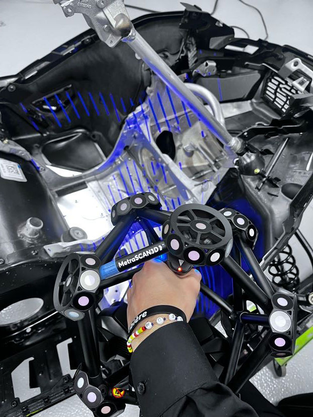 A close-up of the MetraSCAN 3D optical CMM 3D scanner as a student scans a complex snowmobile assembly.