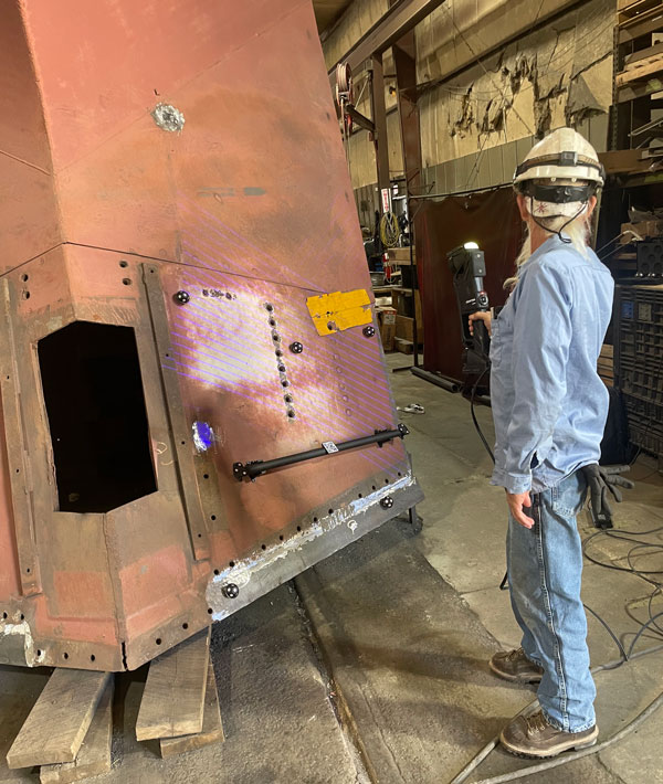 An operator at Mid-America Car 3D scans a huge locomotive part with the HandySCAN 3D|MAX Series metrology 3D scanner.