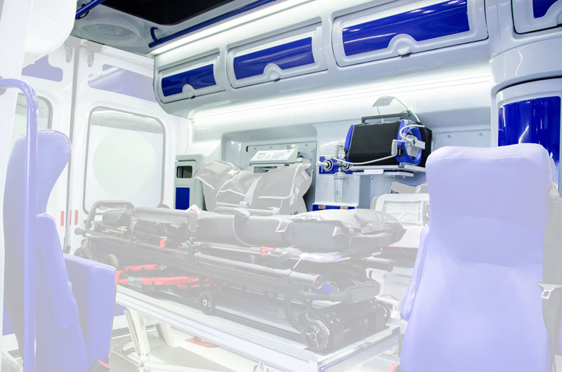 Interno di un'ambulanza con armadietti bianchi e blu personalizzati