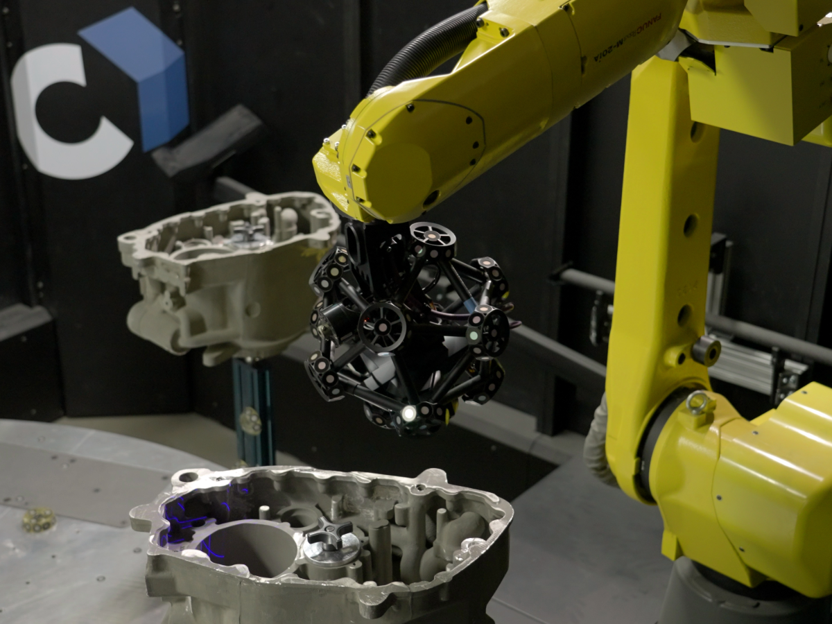 MetraSCAN 3D-R scanner mounted on Fanuc robot in a Cube-R cell measuring a series of gear boxes