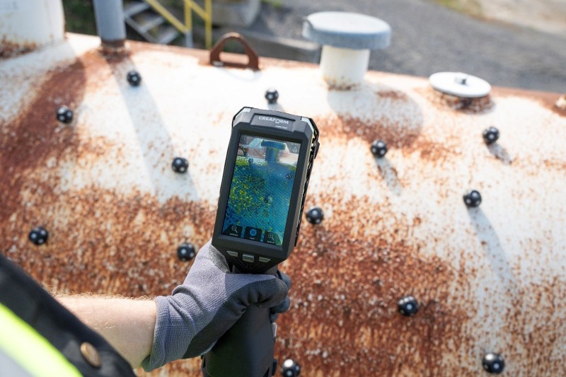 Lo scanner 3D HandySCAN EVO|Elite utilizza la visualizzazione con realtà aumentata per ispezionare all’esterno un serbatoio pressurizzato corroso; diversi target di riferimento neri applicati per la misurazione 3D accurata.