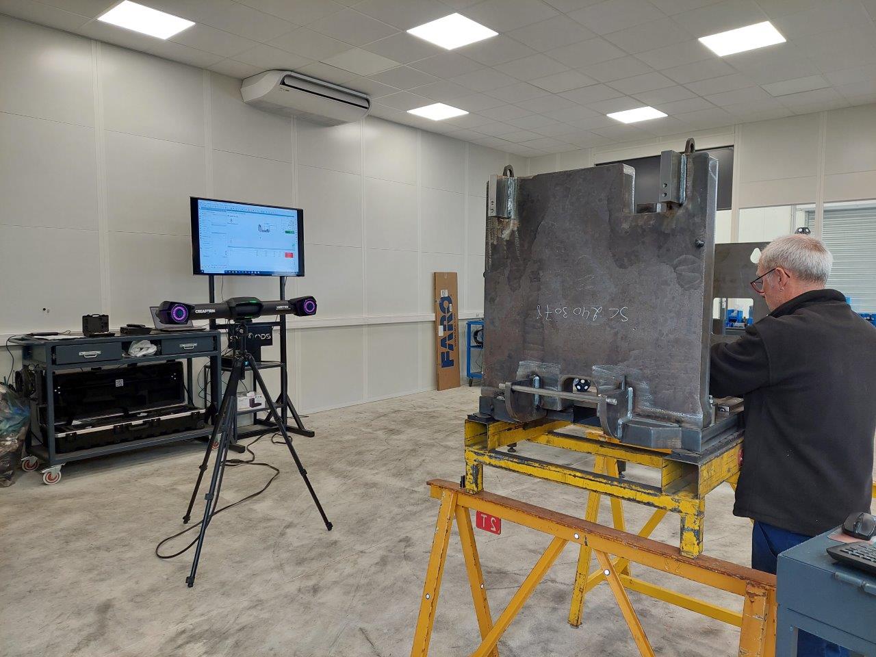 An expert uses the C-Track dual camera sensor, along with the HandyPROBE, to take 3D measurement of a metal component.