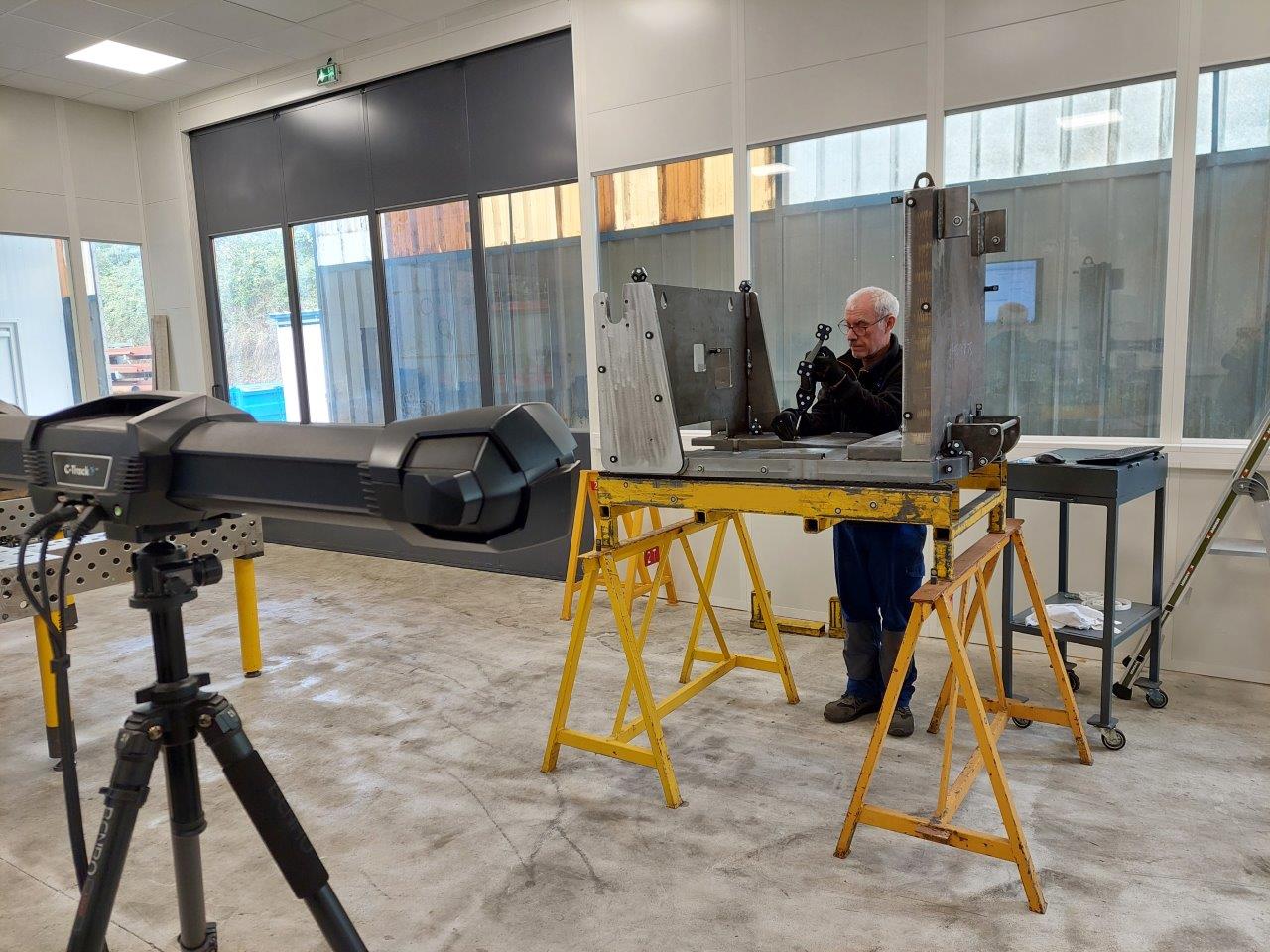 A worker uses the HandyPROBE to take 3D measurements of a welded chassis.