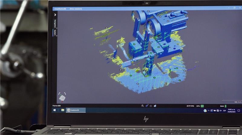 Computadora portátil que muestra el escaneo azul de un dispositivo mecánico dentro de Creaform Metrology Suite.