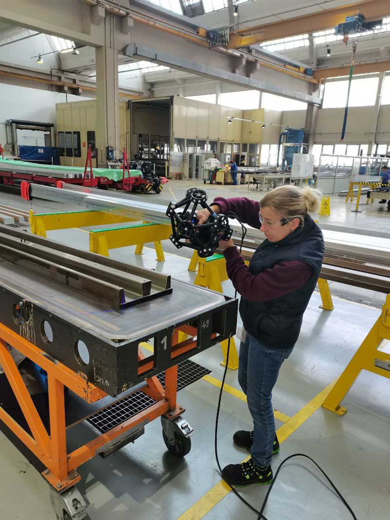 A worker uses the MetraSCAN 3D to scan an aerospace part.