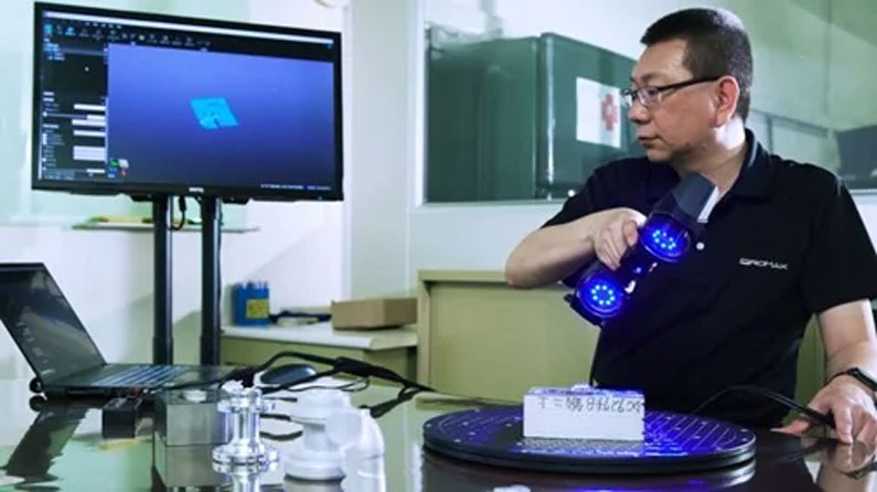 A man scanning a small part using the Creaform scanner