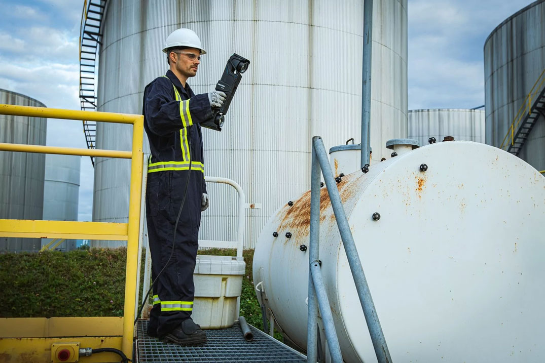 NDT technician inspecting the paint and corrosion of a pressure vessel using the HandySCAN MAX