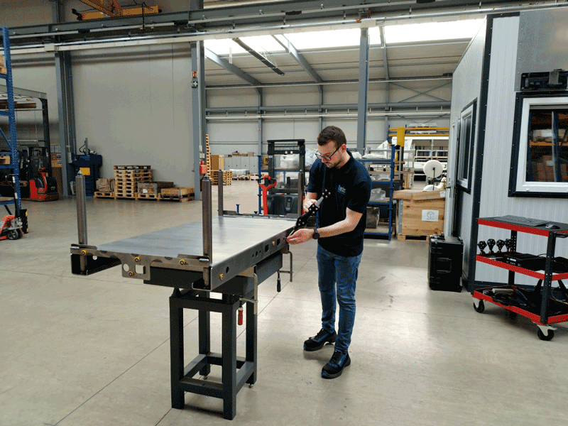 A team member of Brosius GmbH uses the HandyPROBE portable measurement system on a metal component.