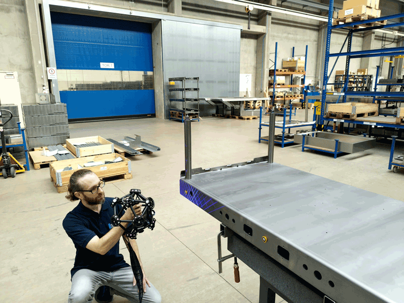 Un dipendente di Brosius GmbH utilizza una CMM portatile MetraSCAN 3D su un componente metallico.
