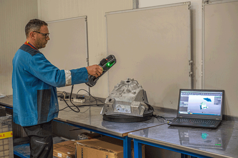 一名 GF Casting 员工使用 Go!SCAN SPARK 扫描铸件。采集到的数据实时显示在笔记本电脑上的 3D 计量软件中。