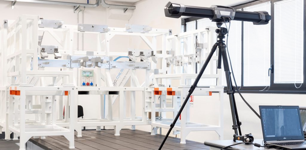 SFM employee on a ladder wearing a white helmet and a respirator, using a MetraSCAN 3D to scan a transformer tank
