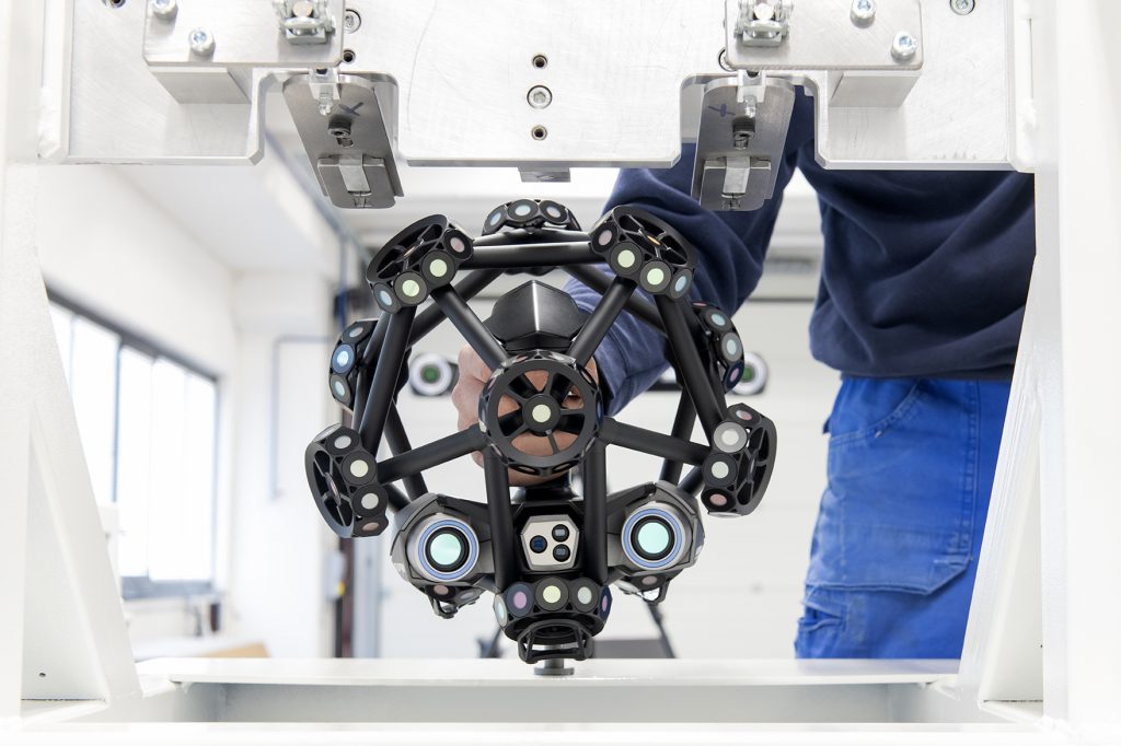 Close up of SFM employee wearing a white helmet and a respirator, using a MetraSCAN 3D to scan a transformer tank