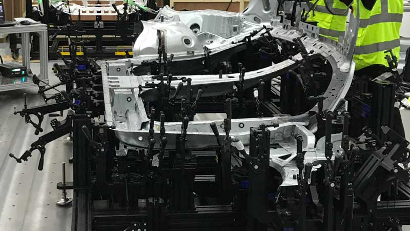 Dispositivo de medición que sujeta una pieza de automóvil estampada