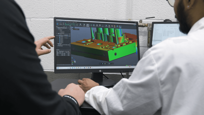 Especialistas en control de calidad observan un mapa de colores mostrado con el software de inspección de Creaform en la pantalla de una computadora.