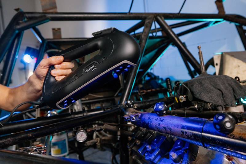Un técnico de EP9 Autosport utilizando un escáner HandySCAN 3D|Serie PRO de Creaform para capturar la geometría de la cabeza de motor del coche de carreras.