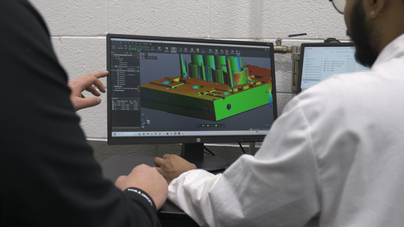 Quality control specialists looking at a colormap displayed with Creaform’s Inspection software on a computer screen