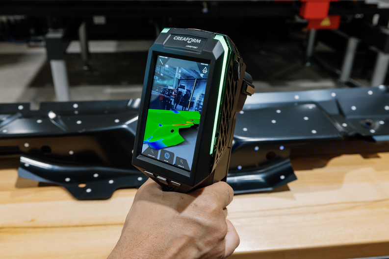 HandySCAN 3D EVO 系列特写镜头,内嵌显示屏实时显示大型深色工件检测的网格数据。