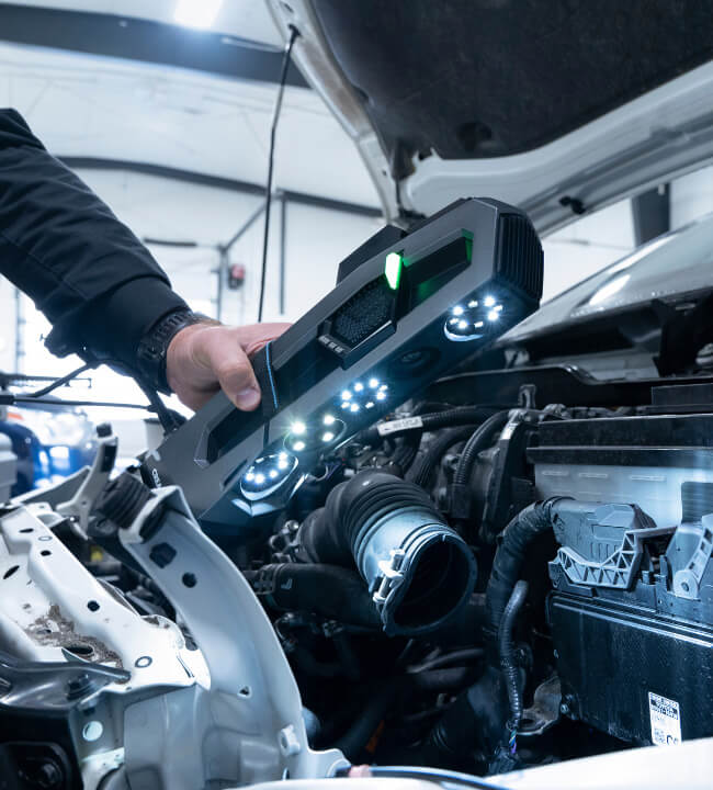 Technician using a portable 3D scanner to capture detailed measurements of an industrial component.