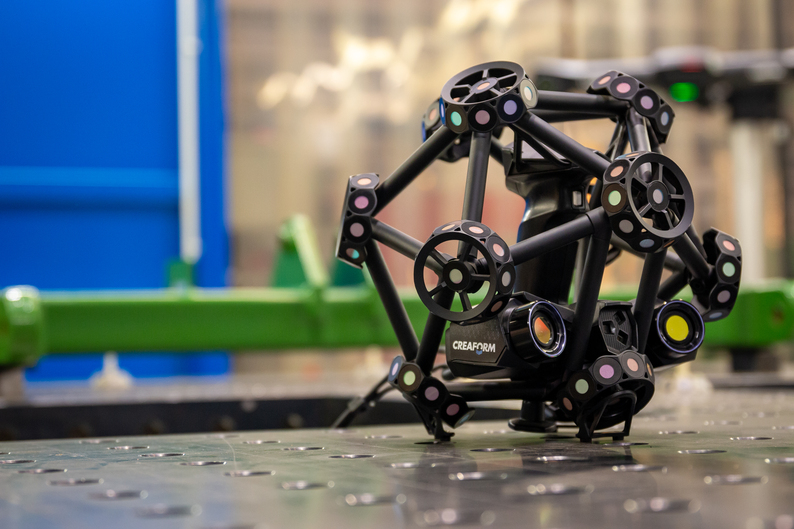 Creaform MetraSCAN 3D su un tavolo in un ambiente industriale.