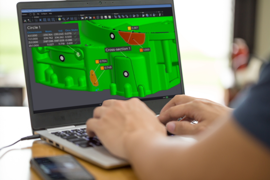 Employee working on a laptop displaying the part in the Inspection module of the Creaform Metrology Suite