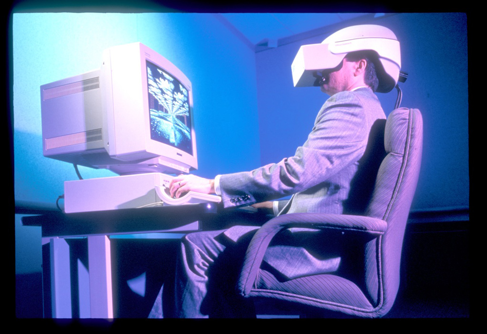 Men in front of computer with vintage virtual reality headset