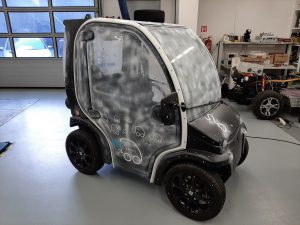 Small black and white electric vehicle in a workshop