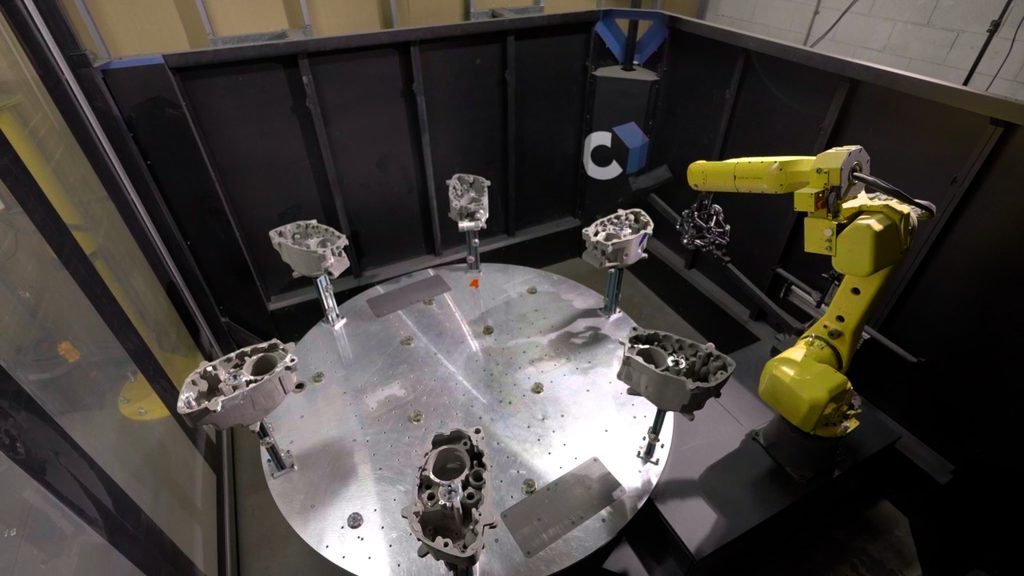 Cube-R incluant le MetraSCAN-R BLACKΙElite HD monté sur robot numérisant six pièces sur une table tournante