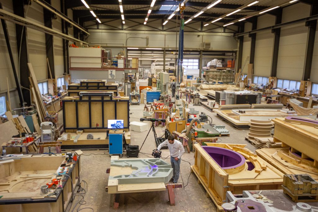 Blick in die Produktionshalle der Duisburger Modellfabrik GmbH mit einem Mitarbeiter, der ein Teil mit dem Creaform MetraSCAN 3D scannt