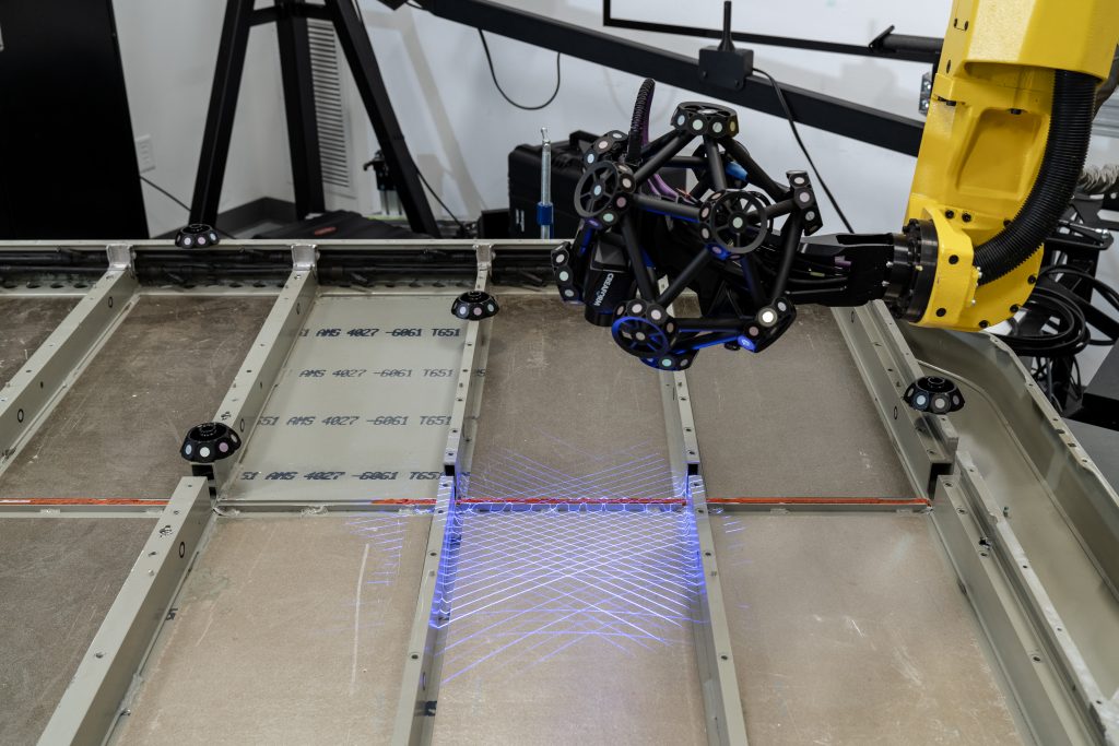 MetraSCAN-R montato su robot che misura una lastra di metallo piatta