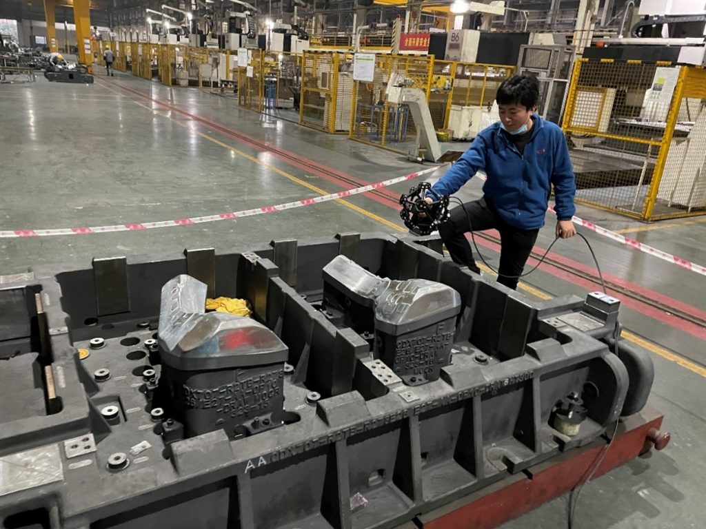Employee on the production line using a MetraSCAN 3D scanner to measure stamping dies