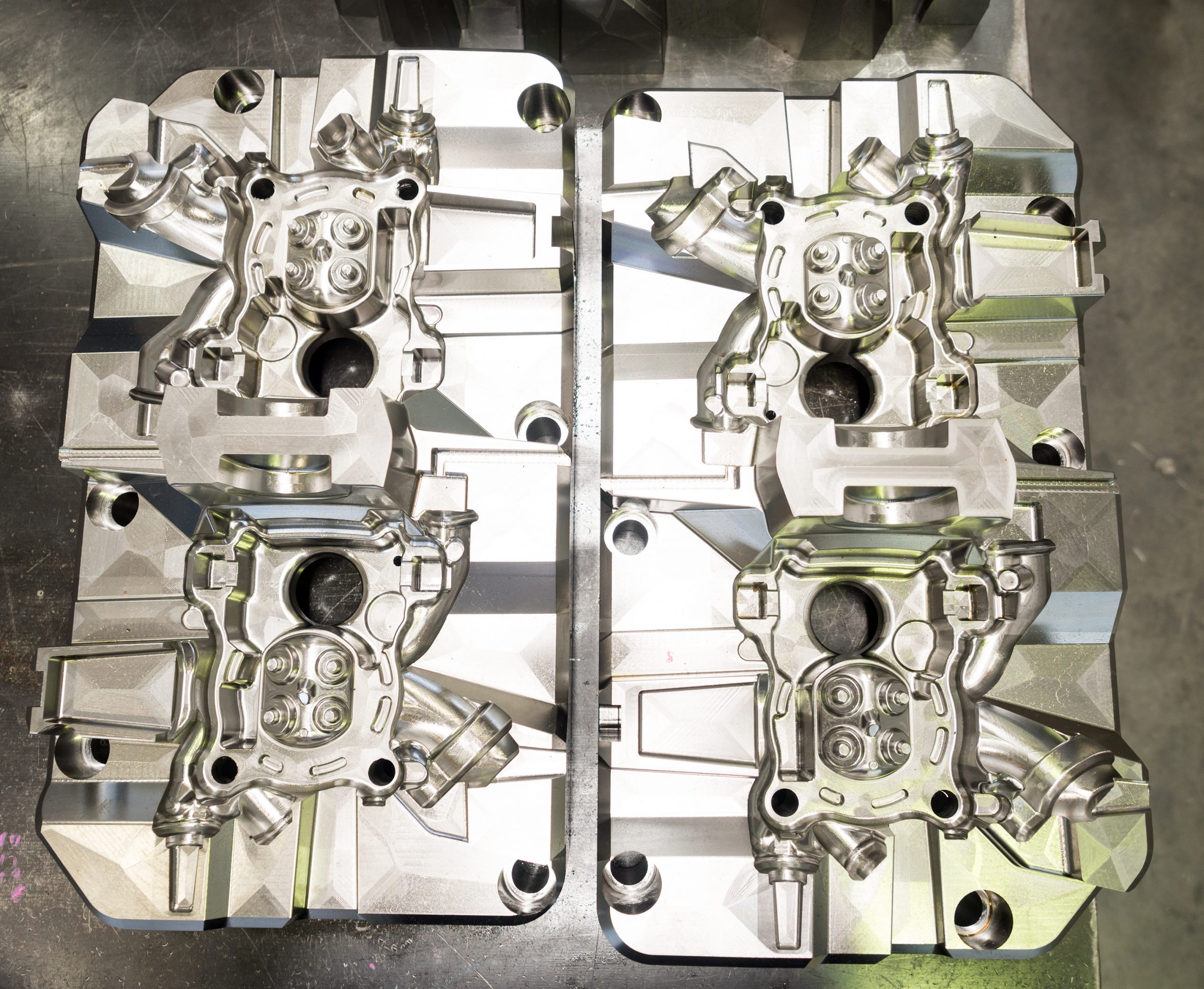 Four high precision manufactured mold and die for automotive placed on a metal table