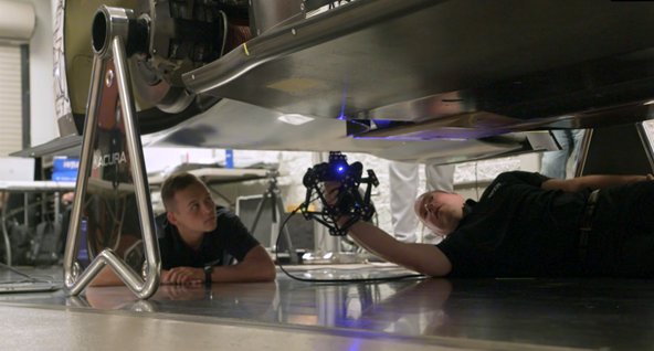两名员工使用便携式计量级光学扫描仪 MetraSCAN 3D测量一辆赛车的车身底部