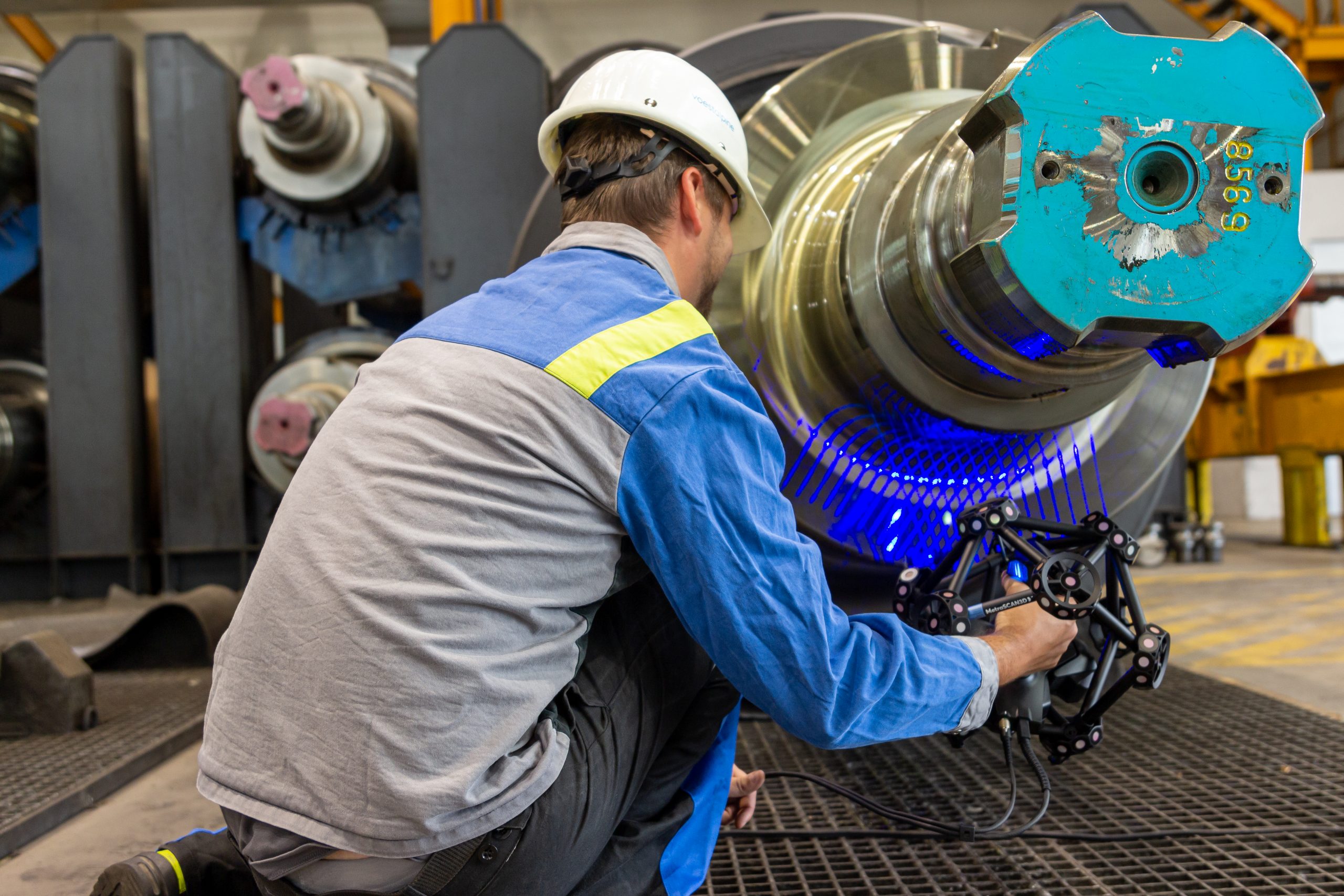 Um engenheiro realiza a digitalização de um eixo de acabamento brilhante com o escâner MetraSCAN 3D diretamente no chão de fábrica.