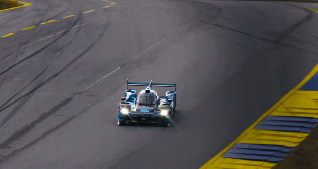 Blue racing car driving on a tarmac race track