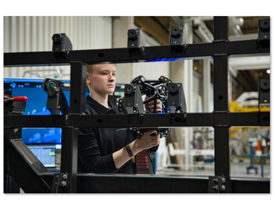 HOLON engineer using a portable MetraSCAN 3D to capture 3D data of a vehicle frame structure during large-part inspection.