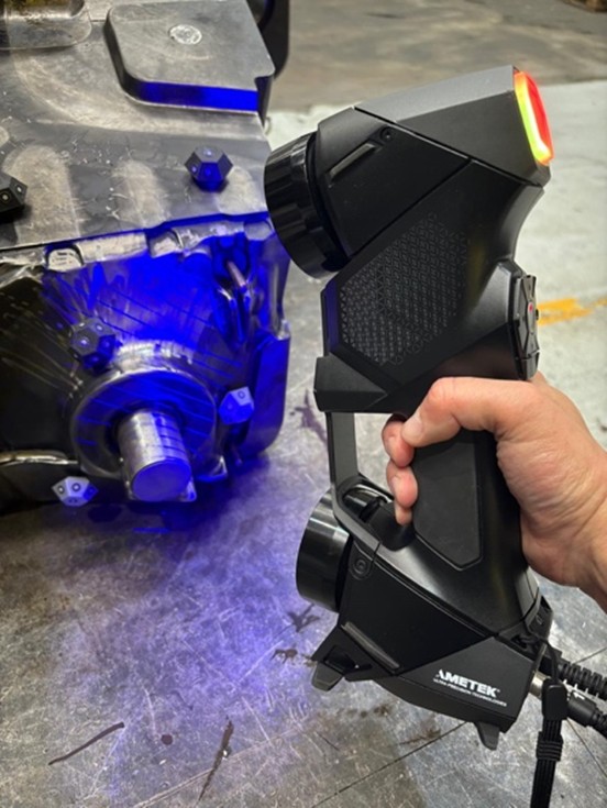A picture of the HandySCAN BLACK™|Elite 3D scanner in the hands of a technician as they scan a part.